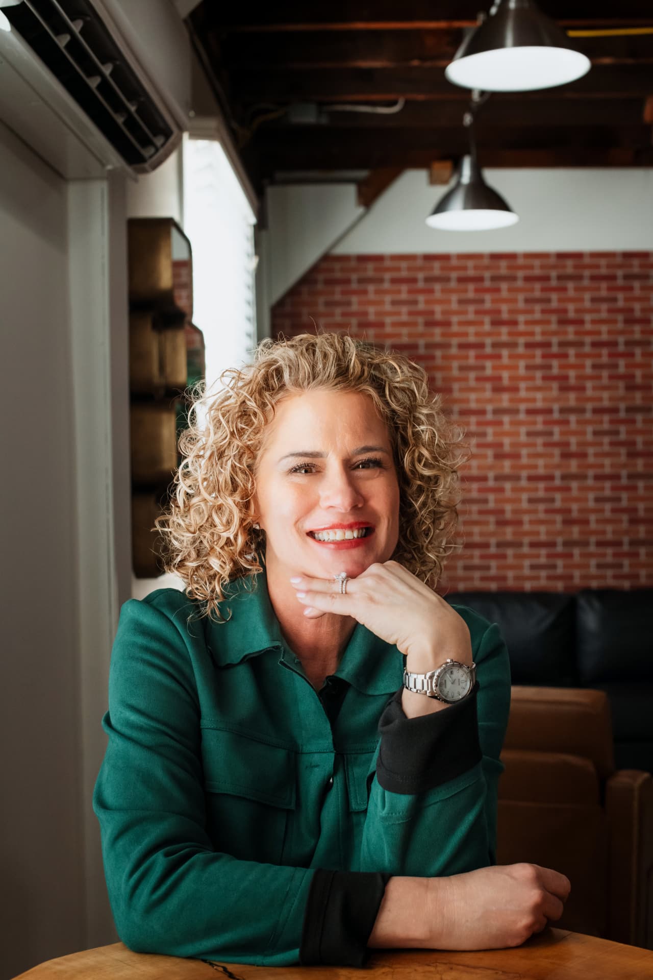 Val Gallagher seated at a table in a green jacket